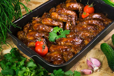 Chicken wings baked in barbecue sauce in a metal tray. home cooking. rustic style.の写真素材
