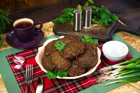 Lentil Patties. Fried vegetable bean cutlets. Served with sour cream, fresh herbs, parsley, green onions.の写真素材