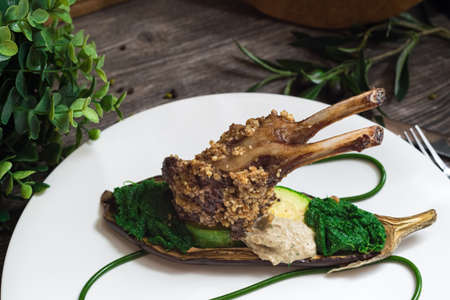 Rack of lamb in nut batter with baked vegetables. Spinach paste and baked eggplant. molecular food.の写真素材