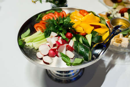 Metal tray with sliced fresh vegetables. Celery, tomatoes, yellow peppers, cucumber, radishes, dill.の写真素材