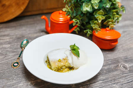 Katmer - Turkish crispy pancakes made of phyllo dough with pistachios, honey syrup, and vanilla ice creamの写真素材