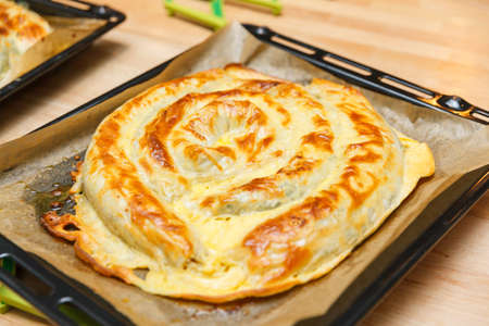Turkish national snail pie Kolberegi made of crispy filo dough with spinach and suluguni filling in sour cream and egg jamの写真素材