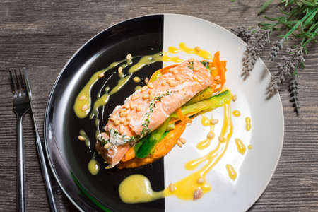 Salmon steak on a plate with Thai vegetables and sweet and sour mango sauceの写真素材
