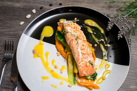 Salmon steak on a plate with Thai vegetables and sweet and sour mango sauceの写真素材