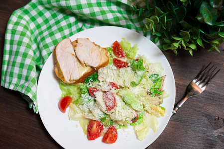 A plate of Caesar salad view from above. Iceberg lettuce, cherry tomatoes, parmesan cheese, chicken filletの写真素材