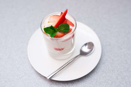 Strawberry parfait with mango sauce decorated with mint leavesの写真素材