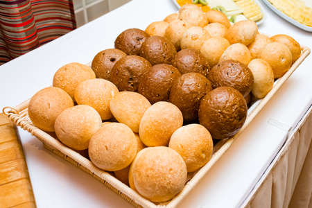 Breadbasket. Round buns assortment on buffet table. Wheat bread, rye bread. Freshly baked bread.の写真素材