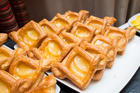 Puff pastry with peach jelly. Layout on the buffet table. Crispy dough. fresh baked goods.
