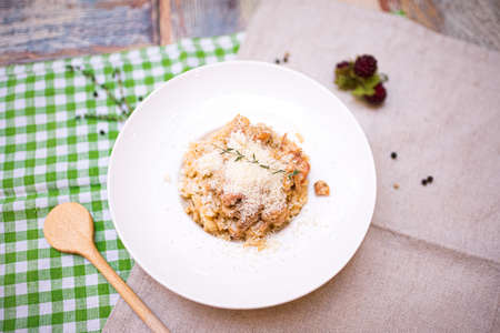 a portion of risotto with seafood and parmesan cheese grated on top. one plate on the table top view.の写真素材