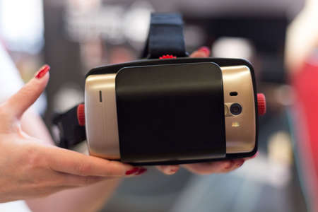 Female holds VR glasses with a smartphone. Test drive option to try out VR technology.の写真素材