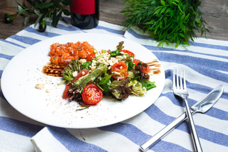 Salad with salmon, crushed cashew nuts, cherry tomatoes, balsamic sauce and grapefruit slicesの写真素材