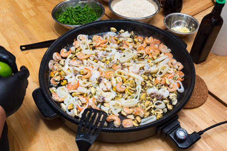 Seafood fried in a paella dish (paella pan). Seafood cocktail. Shrimp, squid, octopus, mussels.の写真素材
