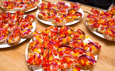 Plates with a huge amount of tapas appetizers. Slices of bread with spread cream cheese and diced...