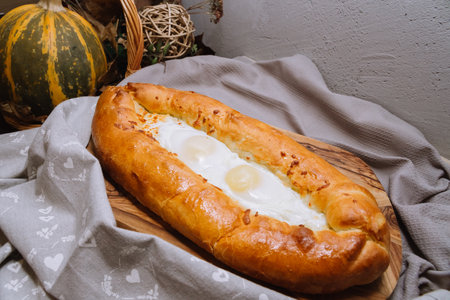 Baked Adjarian-style hot khachapuri with eggs and melted cheese right from the oven are resting on...