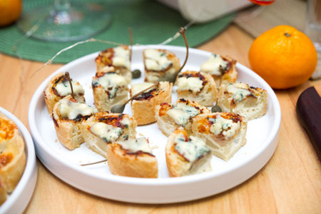 A plate of sliced tartlets with gorgonzola (edible moldy cheese). Bit size portions.の写真素材