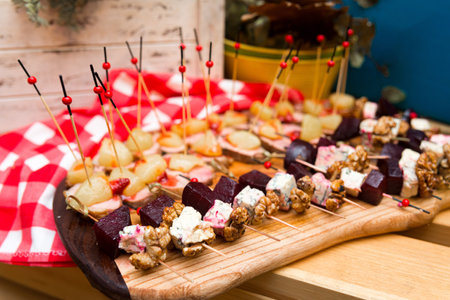 assorted canapÃ©s: skewer of beet cheese slice with mold and walnuts, skewer of duck breast meat with pineapple sliceの写真素材