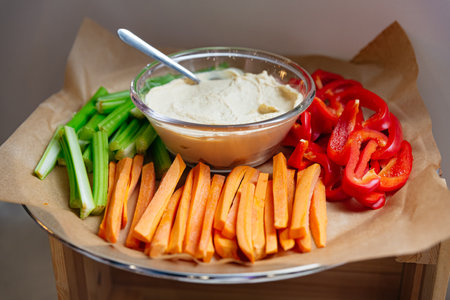 fresh vegetable sticks and hummus dip. Fresh, crunchy vegetables like celery and carrots are paired with bell peppers for a healthy snack dip. Perfect for fast food on-the-go or maの写真素材