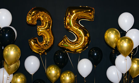 Celebrating 35 Years with Gold and Black Balloons. A festive birthday celebration with black and...