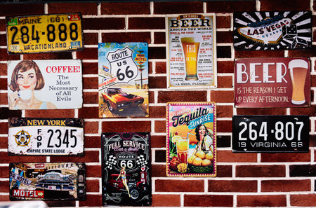 Moscow, Russia - March 21 2023: a bunch of metal car plates on a brick wall, bar interior, american car plates, route 66, plate, carsのeditorial素材