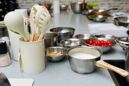 cooking and food concept - close up of set of kitchen utensils and raw ingredients before cooking...