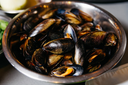 A bowl filled with fresh, defrosted mussels ready for cooking, perfect for seafood recipes.の写真素材