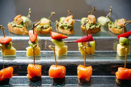 An exquisite catering display featuring shrimp canapÃ©s and skewers of fresh fruit, artfully...