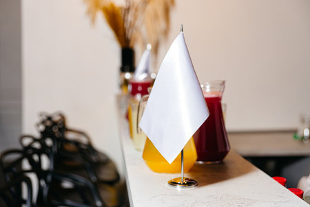 Colorful juice pitchers lined up on a counter, marked with white flags, prepared for guests at a catering event or buffet.の写真素材