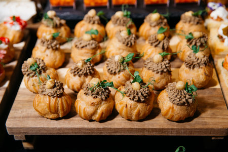 Elegant canapé selection featuring golden choux puffs filled with savory mushroom mousse, topped...