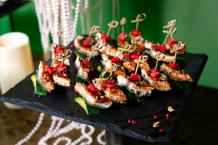 Elegant teriyaki chicken bites with sesame seeds and pickled garnish served on zucchini slices,...