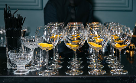 Multiple wine glasses lined up with orange slices inside, ready for drinks at a party or cocktail event.の写真素材