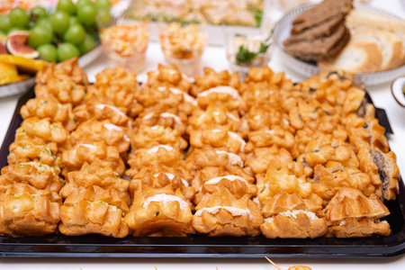 A large catering tray filled with assorted savory cream puffs, perfect for party appetizers or...
