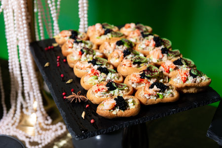 Elegant seafood canapÃ©s filled with shrimp, salad mix, and topped with black caviar, perfect for upscale parties and receptions.の写真素材
