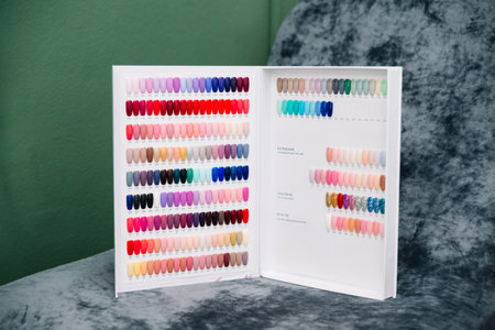 Open nail polish color chart showing various gel and acrylic shades for manicure selection in a beauty salon setting.の写真素材