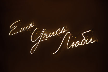 Glowing neon sign in Russian with the words (Eat Learn Love) on a dark background, modern decor...