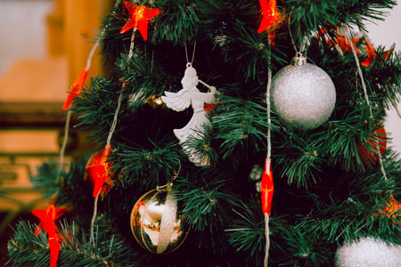 A beautifully adorned Christmas tree showcasing ornaments, glowing lights, and vibrant decorations, invoking traditional holiday cheer and seasonal warmth.の写真素材