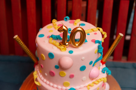 A festive birthday cake adorned with colorful polka dots and a number ten topper. spiraled...