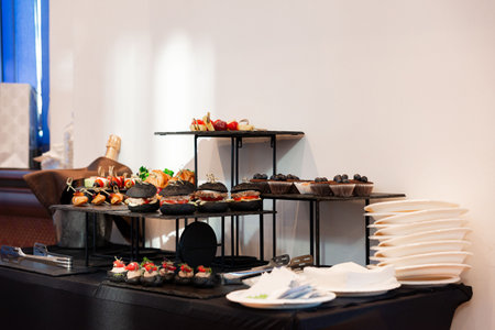 A stylish buffet setup featuring gourmet appetizers on tiered stands. the arrangement includes...