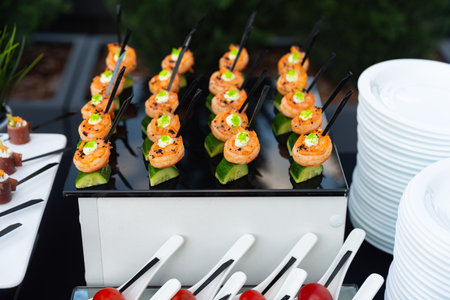 A beautifully arranged selection of gourmet appetizers featuring shrimp on cucumber slices. perfect for events, these bite-sized treats add a touch of elegance to any platter.の写真素材