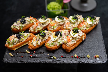 A delectable arrangement of eclairs filled with a savory mix, topped with sliced eggs, greens, and caviar. perfect for elegant gatherings and special events.の写真素材