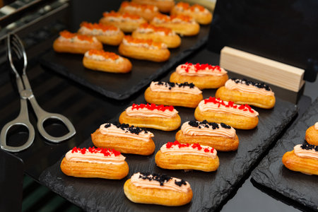 A selection of delicious eclairs creatively decorated with colorful toppings, displayed elegantly on...