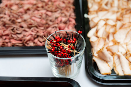 An appealing display of sliced meats paired with decorative skewers. perfect for gatherings and events, this setup highlights culinary presentation and variety.の写真素材