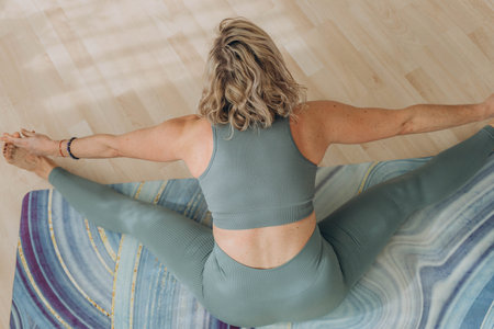 A 50-year-old woman does yoga at home