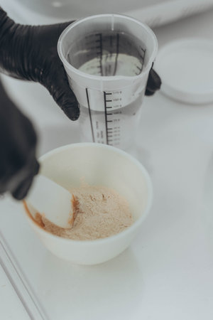 A woman cosmetologist makes an alginate mask