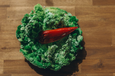 Red paprika on green mold and moss.