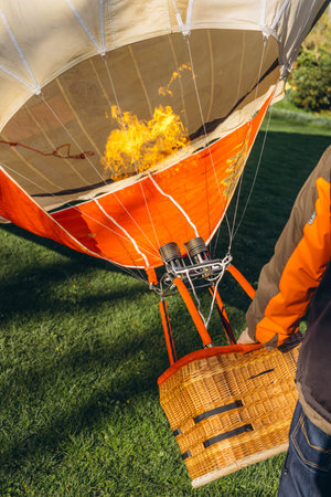 A man inflates a balloon at a balloon festivalのeditorial素材