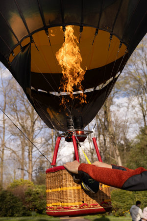 A man inflates a balloon at a balloon festivalのeditorial素材