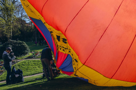 A man inflates a balloon at a balloon festivalのeditorial素材