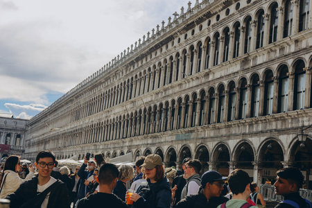 Venice, Italy - Italy 2, 2023: Crowds of tourists strolling on the cobblestone alley near Grand...