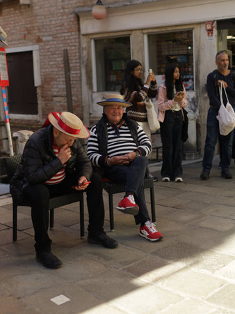 Venice,Italy-April 2, 2023: Gondolier waits for tourists in a picturesque canal in Venice.のeditorial素材