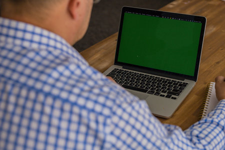 Cropped image of man working on a laptop at home